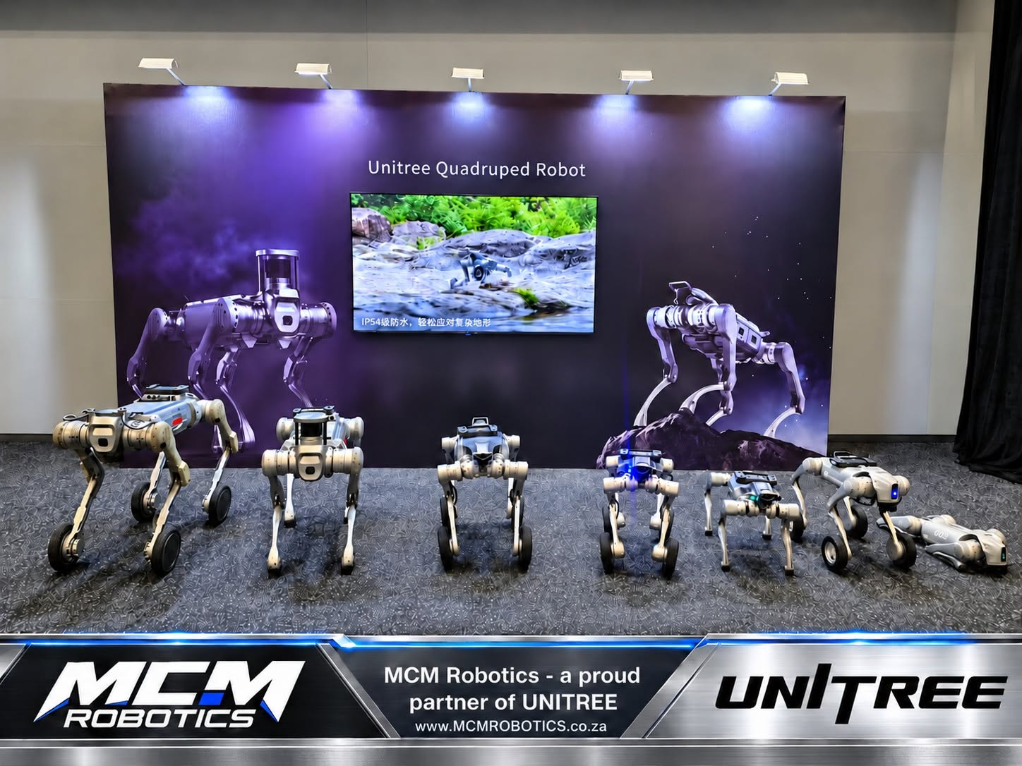 The Unitree quadruped robot range on display, with the MCM Robotics and Unitree partner banner